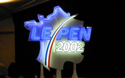 Diaporama Il y a neuf ans... - Le décor du FN, lors d'un meeting de son chef. | Photo OP, Wikimedia Commons.